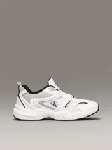 Zapatillas urbanas Calvin Klein Jeans, de estilo retro, color blanco con detalles en plateado y negro. Confeccionadas en malla y cuero sintético, con logo CK en el lateral.