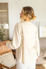 Blusa de estilo clásico, color negro, con detalle de v en el escote y mangas largas.