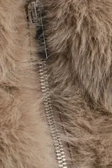 Chaleco de tejido suave con efecto de pelo sintético en color tostado. Presenta cuello elevado, cierre frontal de cremallera, sisas amplias y bolsillos laterales discretos. Posee un elástico oculto en el bajo para una silueta abullonada y está completamente forrado.