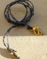 Collar con dije de caracola dorada y cordón fino azul.
