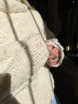 Sweater de lana color crema, tejido a mano con punto grueso.