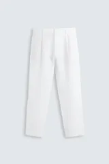 Pantalón de vestir blanco, confeccionado en lino, de corte recto, con bolsillos laterales y traseros. Se ajusta a la cintura con botón y cierre.