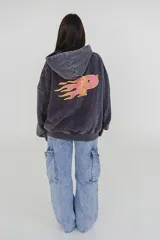 Canguro negro con capucha y bolsillo delantero tipo canguro. Estampa frontal con la frase "Wear More & Worry Less" en color rosa.
