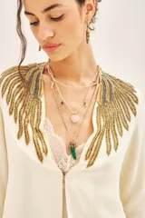 Saco corto color crema con escote en V y mangas 3/4. Confeccionado en viscosa crepe con bordado de mostacillas, canutillos y lentejuelas doradas.