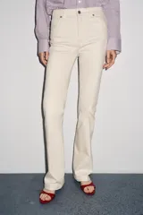 Pantalón de jean azul oscuro, de tiro bajo, corte slim fit y bootcut. Con cinco bolsillos y cierre frontal con cremallera y botón.