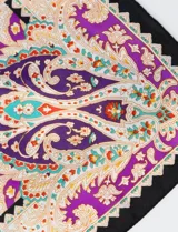 Bandana cuadrada de satén con estampado de arabescos en tonos violeta, naranja, celeste y blanco, con borde negro.