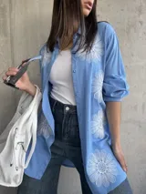 Camisa celeste de manga larga con bordados de flores blancas.