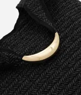 Bolso de playa tipo saco confeccionado en paja de papel color negro, con asa circular de metal dorado.