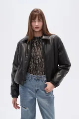 Campera estilo bomber de eco-cuero negra, con cuello camisero, cierre frontal y puños y cintura ajustados con elástico.