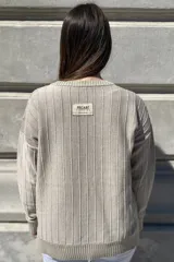 Sweater negro de tejido de punto con escote en V y rayas verticales plateadas.