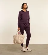 Pantalón deportivo color morado, de algodón y poliéster, con cintura elástica y bolsillos laterales.