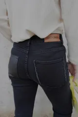 Pantalón de jean negro de corte recto y tiro alto, con bolsillos delanteros y traseros.