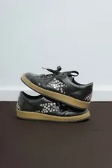 Championes deportivos de cuero y gamuza color dorado metalizado y marrón. Suela de caucho color crema con línea roja. Cordones color crema.