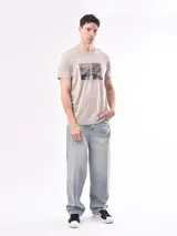 Remera gris con estampa rectangular con imagen de paisaje y texto.