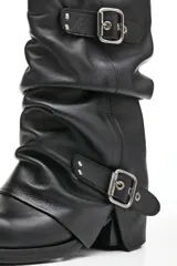 Bota de cuero negro con caña media arrugada, dos correas con hebillas plateadas y taco bajo.