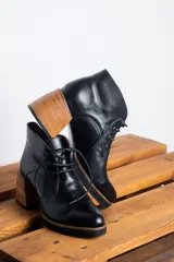 Botines acordonados de cuero negro con tacón de madera.