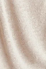 Musculosa color beige claro en punto texturizado con escote redondo y abertura de cerradura con botón en la nuca. Sin mangas.