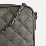 Bandolera clásica color beige, confeccionada en cuero natural, con diseño acolchado en forma de rombos. Posee correa de cadena entrelazada con cuero y cierre principal.