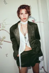 Shorts mini color verde militar, de tiro medio con trabillas, bolsillos delanteros y traseros. Cierre frontal con cremallera, botón interior y gancho metálico.