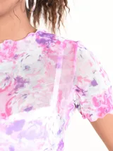 Blusa corta de mangas cortas con estampado abstracto en tonos rosados, lilas y blancos.