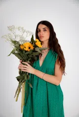 Vestido corto verde esmeralda con bordado calado, escote en V, sin mangas y corte evasé.