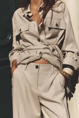 Pantalón marrón de lino, de tiro alto, con bolsillos delanteros y traseros.