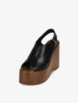Sandalia negra con plataforma de madera y tira trasera ajustable con hebilla.