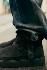 Botín negro de caña baja con interior de efecto pelo y suela tipo flatforma.