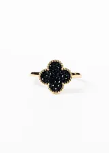 Anillo dorado con forma de trébol de cuatro hojas relleno con micro zirconias negras.