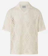 Camisa polo de mangas cortas color crema, confeccionada en tejido de punto calado con cuello inglés.