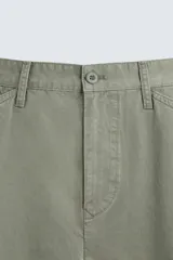 Pantalón cargo de algodón color verde oliva, corte regular fit, con bolsillos laterales con fuelle y solapa, y efecto lavado.