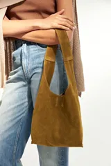 Bolso tote pequeño de cuero color marrón, con asas cortas y diseño minimalista.