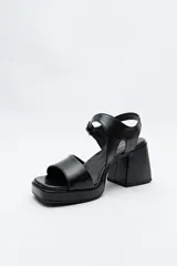 Sandalias negras con plataforma fina y taco ancho forrado. Incorporan pulsera con hebilla metálica y capellada ancha.