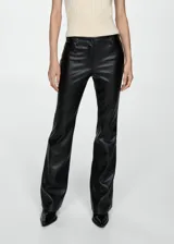 Pantalón negro de tiro medio con efecto piel, corte flare, cierre de cremallera y botón, trabillas, cinco bolsillos y diseño largo.