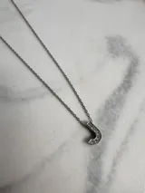 Collar de cadena fina plateada con dije de la letra "F" incrustada con strass.