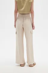 Pantalón cargo color beige de viscosa, tiro alto, corte recto y bolsillos laterales.