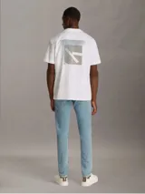 Remera blanca de algodón regenerado con cuello redondo, mangas cortas y corte regular. Estampado frontal con monograma de Calvin Klein en capas. Detalles distintivos de Calvin Klein Jeans.