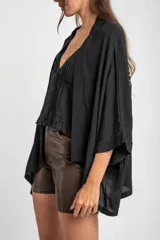 Kimono negro de mangas 3/4 con detalle de flecos en los hombros.
