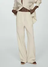Pantalón largo color crema de bambula, corte wide leg y cintura elástica.