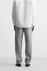 Pantalón de jean gris de corte recto, con cinco bolsillos, efecto lavado y cierre frontal con botones.