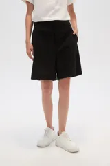 Short de lino color blanco, de calce alto y con bolsillos laterales.