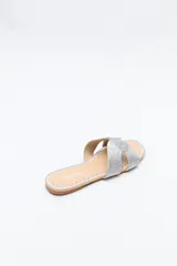 Sandalia baja negra con capellada trenzada tipo cordón, suela plana con bordado a tono.