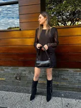 Vestido corto de encaje negro con mangas largas acampanadas.
