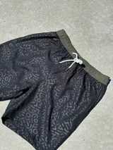 Short de baño negro con diseño gráfico, confeccionado en tela 4-Way Spandex de rápido secado.