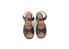 Sandalias de cuero negro con tiras cruzadas, taco cuadrado y pulsera al tobillo con cierre de velcro.