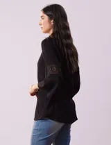 Blusa negra de gasa bambula con cuello a la base y escote en V. Tiene mangas 3/4 amplias con apliques de crochet.