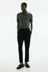 Pantalón negro de sarga con cintura elástica y cordón ajustable, corte slim fit, largo tobillero y dobladillo en el bajo.