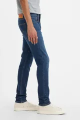 Pantalón de jean azul oscuro, corte skinny taper, con tiro medio y confeccionado en tejido stretch.