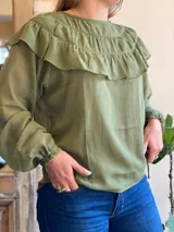 Blusa de gasa azul marino traslúcida con volados en los hombros y mangas largas abullonadas.