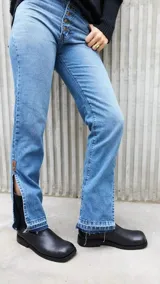 Pantalón de jean celeste de tiro alto, corte recto y etiqueta de cuero marrón en la parte trasera.
